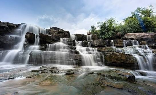 The wide tiered cascade of Chitradhara Falls spilling over flat rock ledges