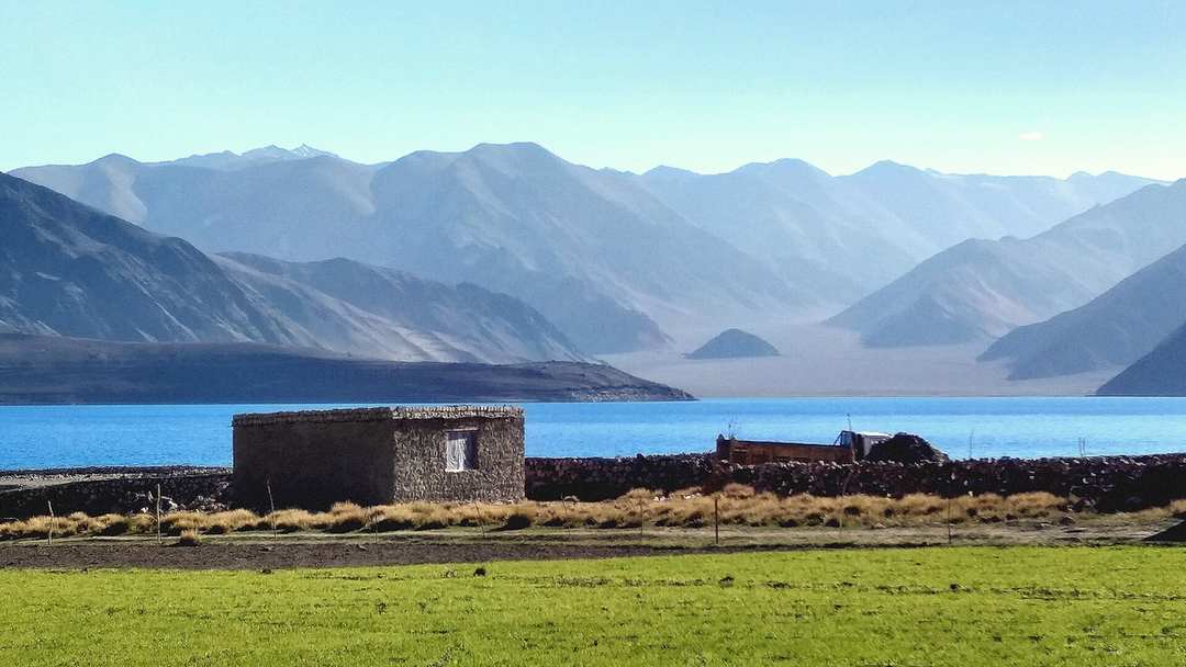 The blue water of Pangong Tso ringed by bare mountains in Ladakh
