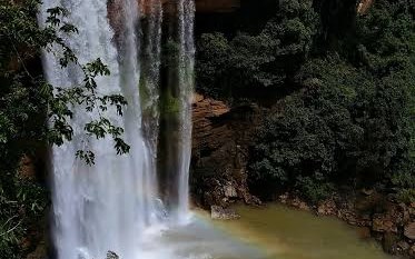 Mendri Ghumar Falls dropping past layered rock into the pool below