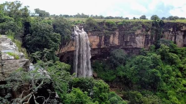 Tamda Ghumar Falls spilling over a wide flat-topped cliff into the forested gorge